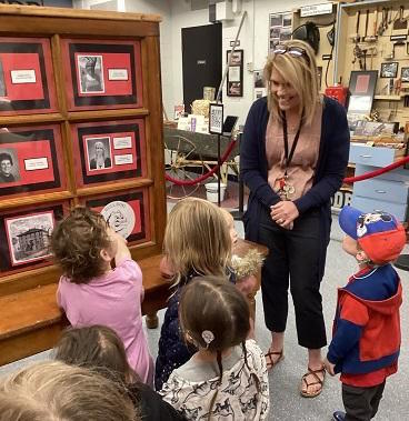 Superintendent Spangler with six preschoolers in the history museum