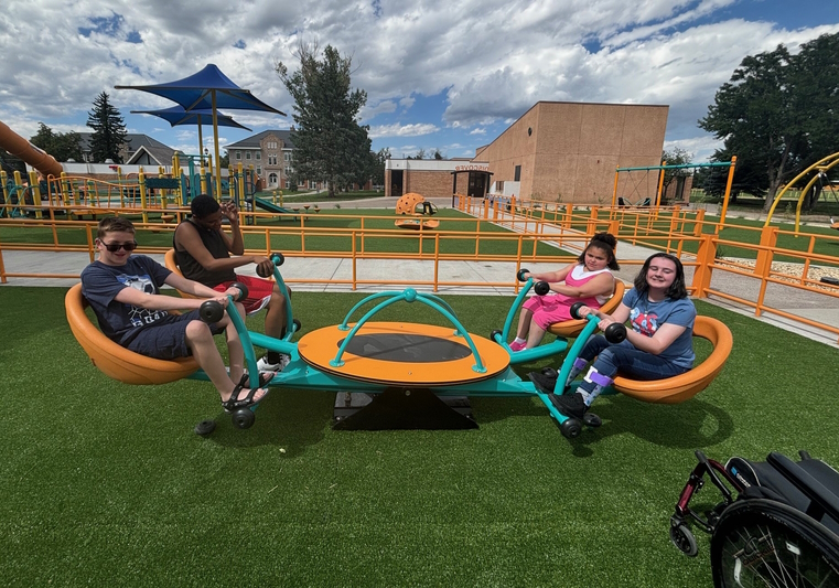 Four students are playing on the four-seater teeter totter