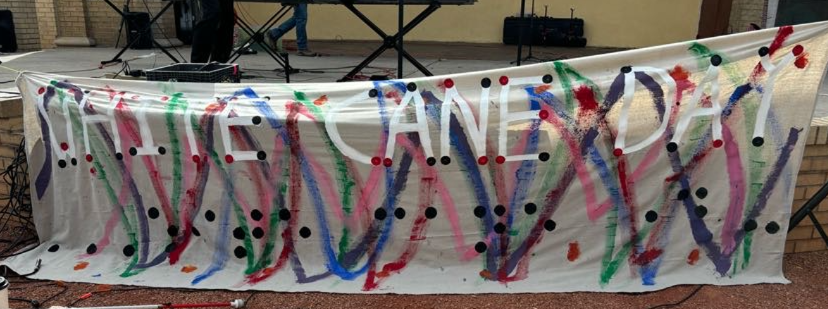 A white sheet with colorful lines and braille alphabet, spelling White Cane Day , spelling White Cane Day.