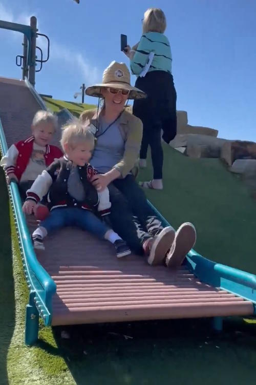 Two children and an adult on a roller slide.