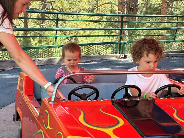 Two students sit in a car on a ride.