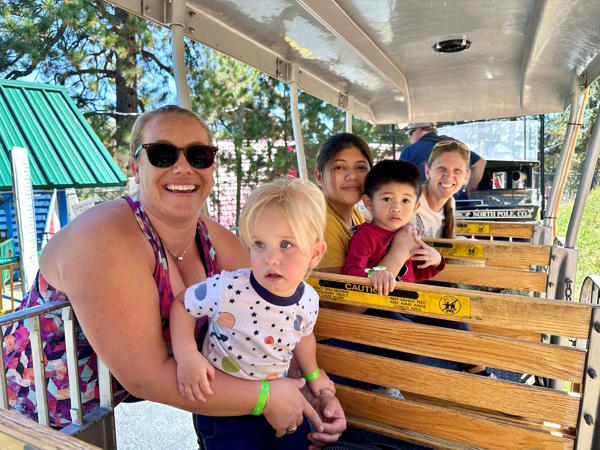 Parents, students and a teacher ride a train.