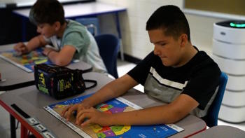 Two students explore tactile and brailed maps. 