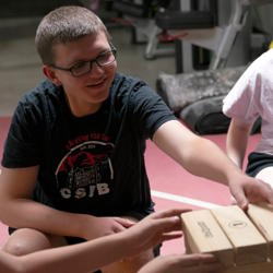 Students place Jenga blocks on top of the stack. 