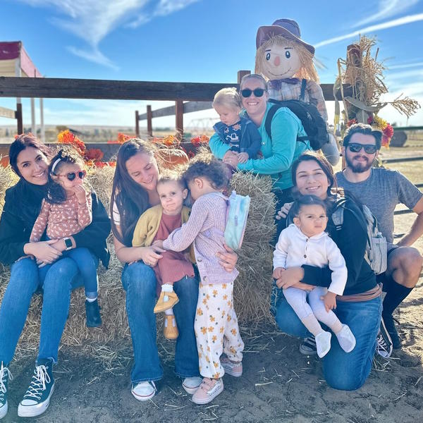 Families in Little Language Learners pose by hay bales. 