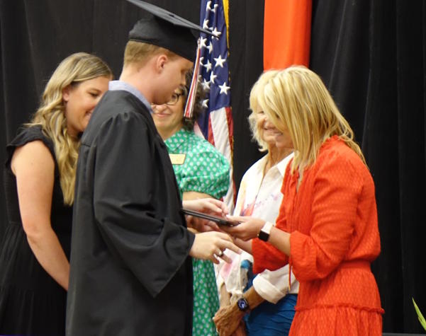Asher receives his diploma from Superintendent Tera Spangler