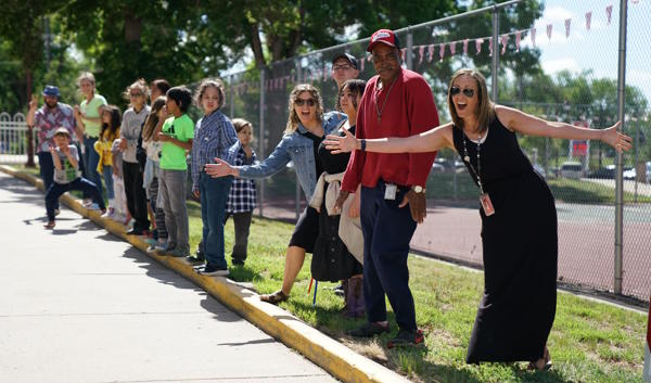 Staff and students cheer on the graduates