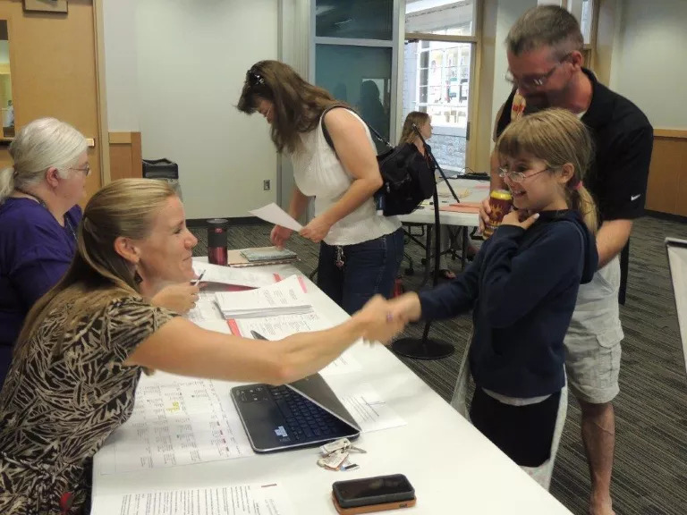 A new student shaking the principal’s hand at registration.