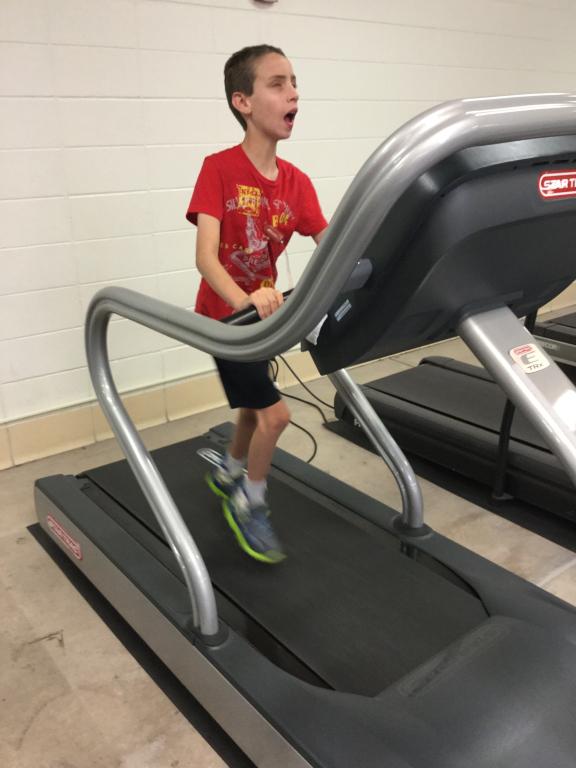 A student runs on a treadmill during adaptive physical education class.