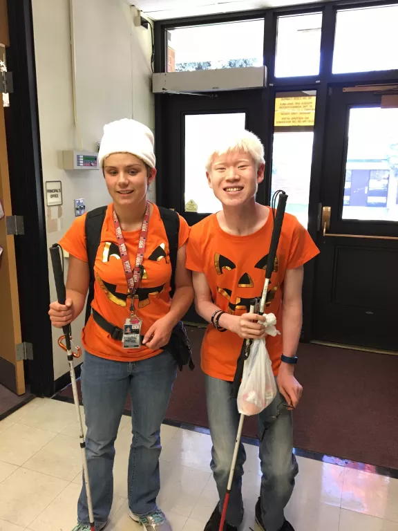 Two students dressed in pumpkin shirts for Homecoming week, celebrating twins day. 