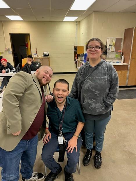 Three BtL students stand together smiling on their last day of school.