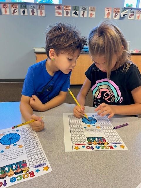 a young boy and girl work on a math paper