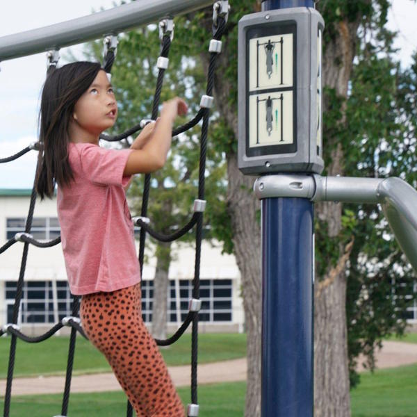 Student climbs on playground equipment