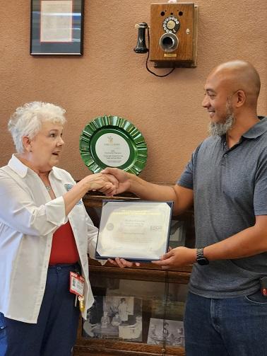 Reuben receives certificate from lady representing ESGR