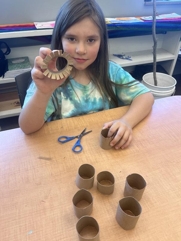 Girl makes floral wreaths out of toilet paper rolls