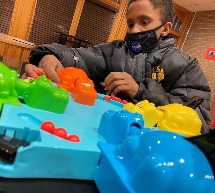 Boy feels a part of the Hungry Hippo board game