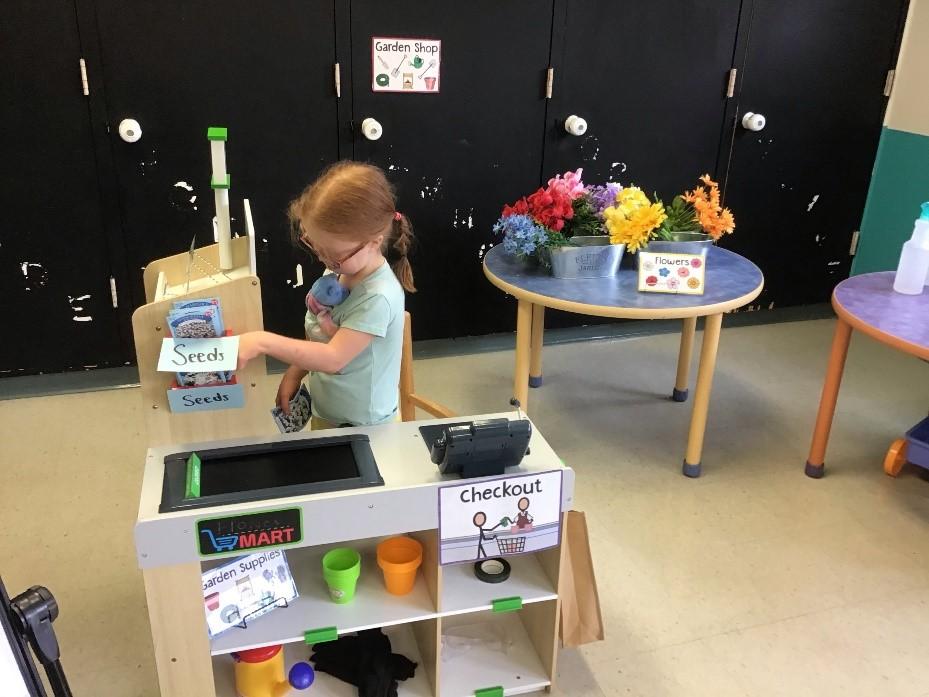 Child with seeds in checkout line of mock store