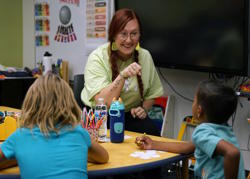 A teacher communicates in ASL with a student.