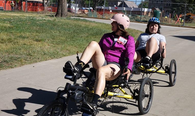 Adult and student pedal on a recumbent tandem bike