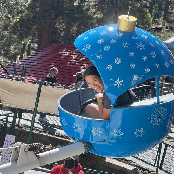 A teacher looks out the side of a ride and smiles at the camera