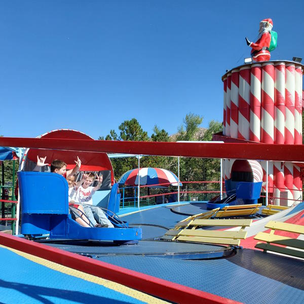 Three students are smiling on a ride.