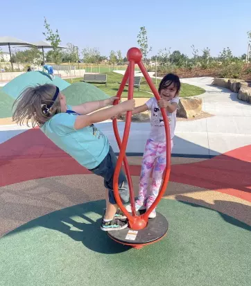 Two students playing on a playground swing