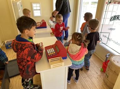 Six preschoolers play near the cash register