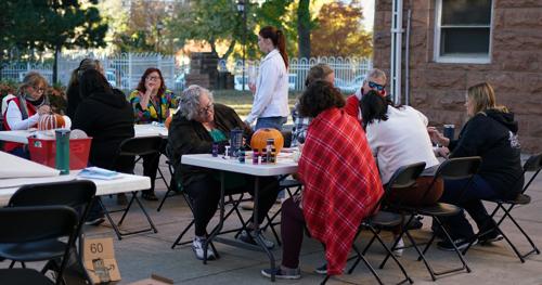 CSDB employees seated at tables decorating pumpkins