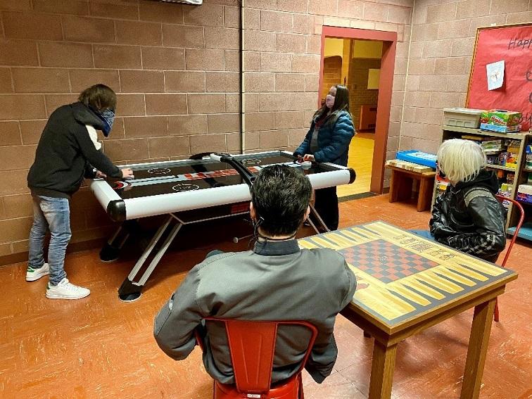 Students play air hockey while others watch