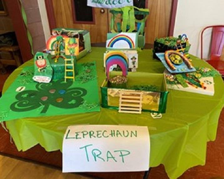 Tabletop filled with pots of gold and rainbows Text: Leprechaun Trap