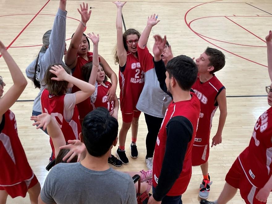 Special Olympics basketball team on the court giving a high 5