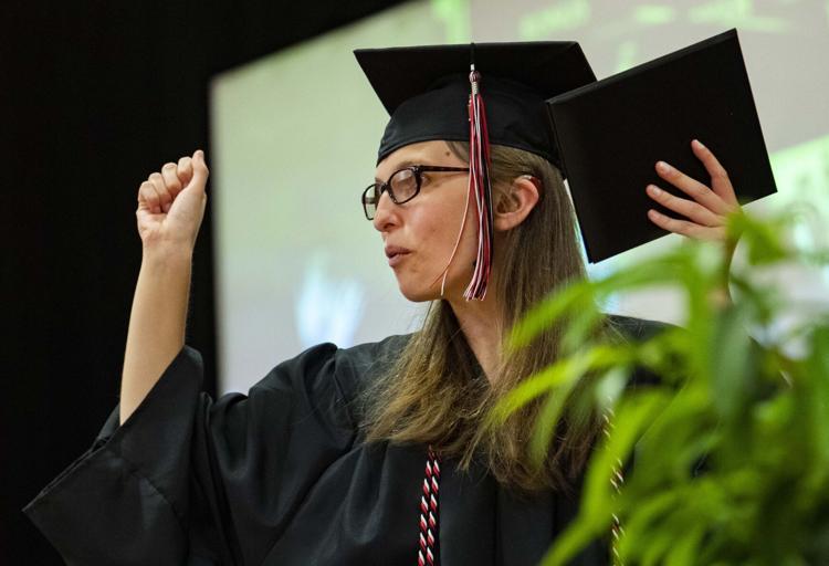 Grad holds diploma and raises hands in victory