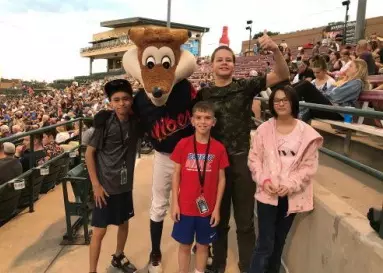 Students at Vibes baseball game posing with a fox mascot.
