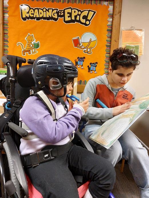 Two girls explore a braille book