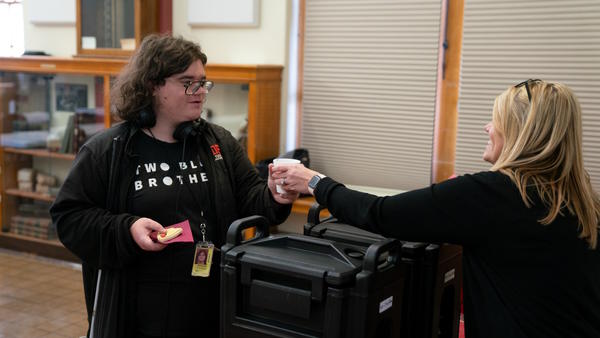 Superintendent Spangler hands a student a cup