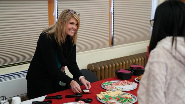 Superintendent Spangler smiles and places a cookie on a napkin for a student.