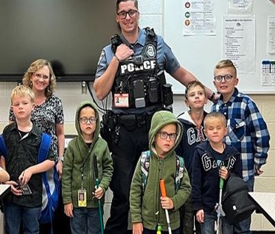Officer Baker with six students and a teacher inside the classroom