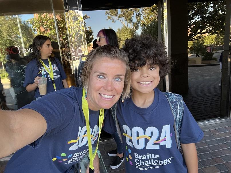 Jamie Lugo and her son in a2024 Braille Challenge shirts take a selfie