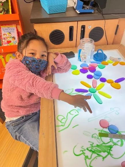 Girl creates a flower design on the light box