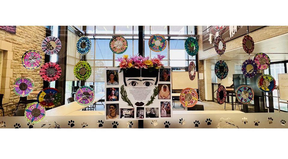 Center collage focused on Frida Kahlo and her art. Handmade Mexican mirrors, in multiple colors and textures, hang around the center collage.