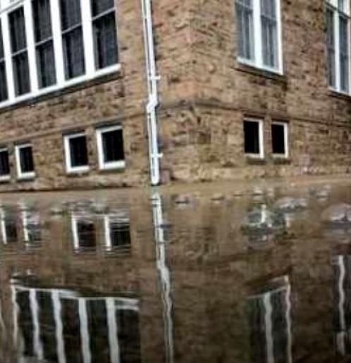 exterior corner of a building reflected in a puddle