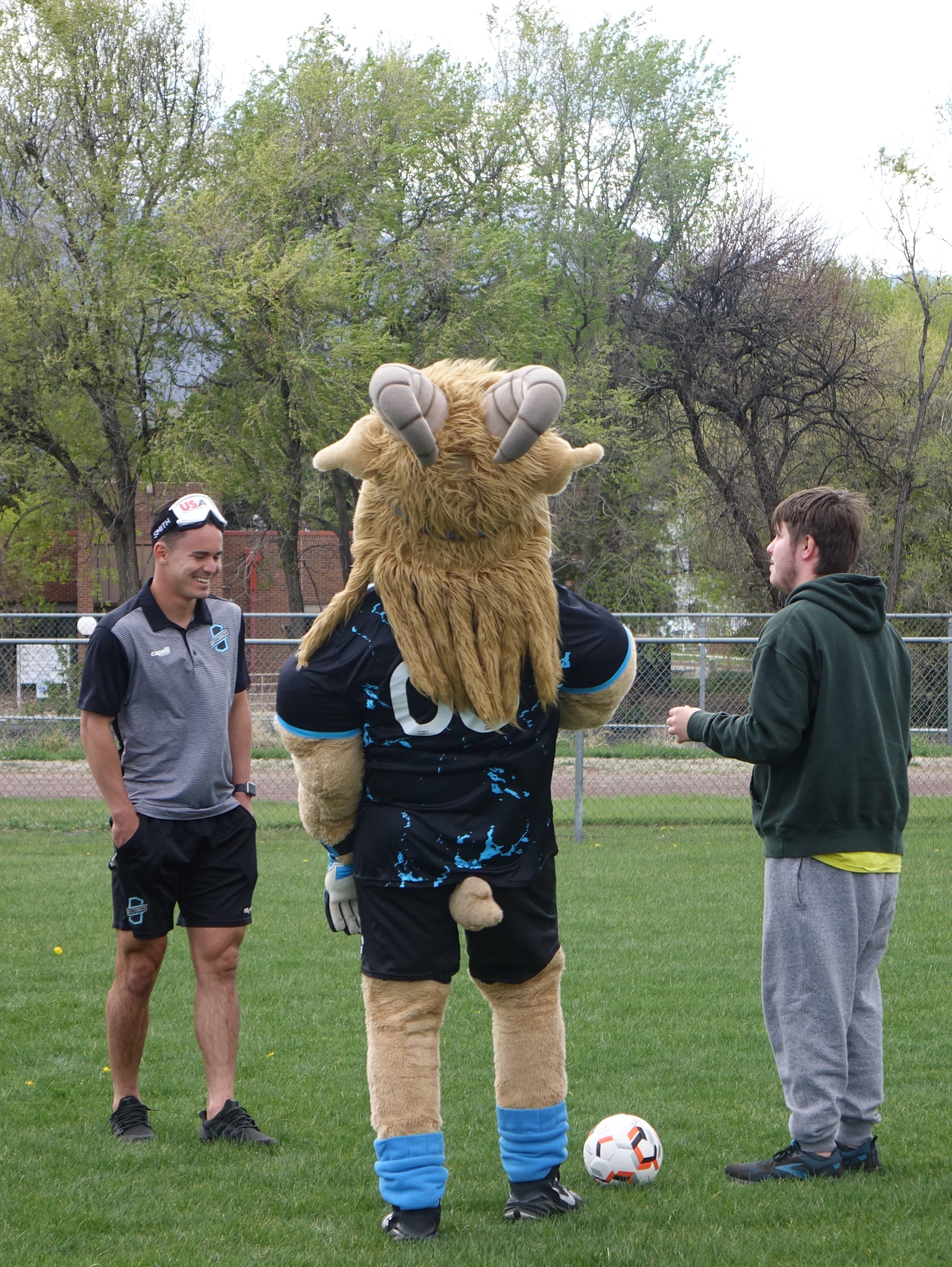 Switchbacks mascot Ziggy with soccer pro and student
