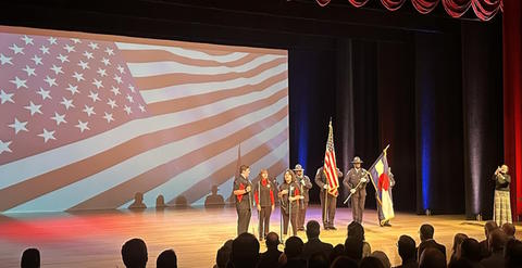 Three CSDB Students on a stage with the El Paso County Sherriff's Office Honor Guard