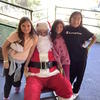 Three students posing with Santa